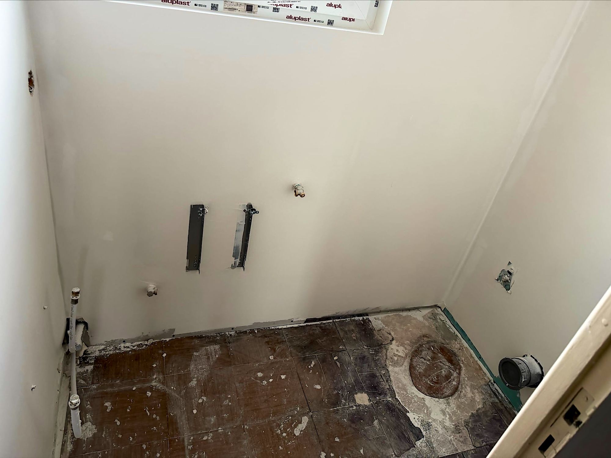 Toilettes à Lille après travaux, murs lisses poncés et arrivées d’eau prêtes pour le bâti-support, prêt à peindre